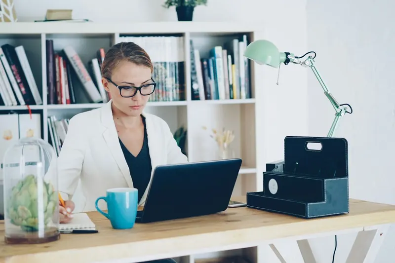 Selbständige Frau arbeitet im Homeoffice am Laptop
